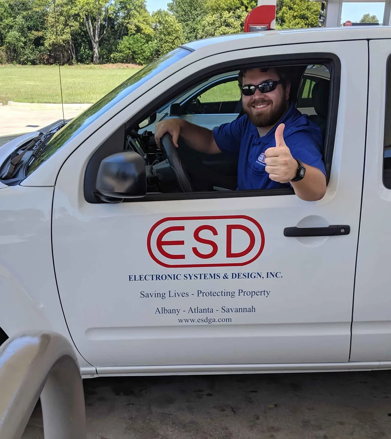 A man in the drivers seat of an electric vehicle.